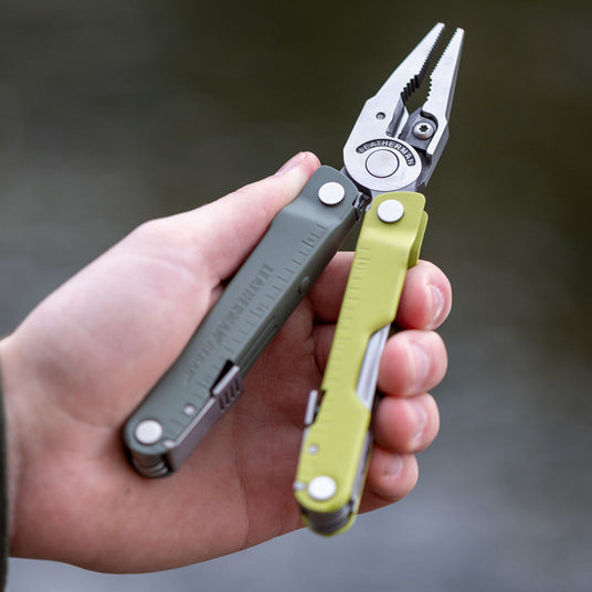 Translation missing: en.Mossy Slate Rebar held in a hand, open to showcase it's pliers, against a blurred background