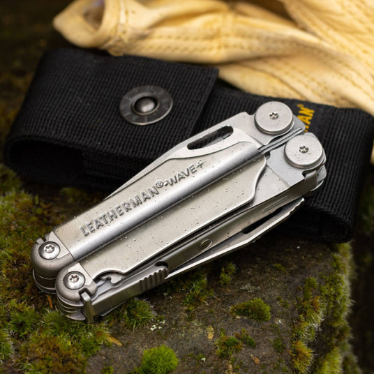 Translation missing: en.Wave Plus closed leaning on a Black Nylon Sheath on a mossy rock next to a pair of gloves