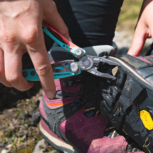 Translation missing: en.Leatherman Skeletool CX pliers used to remove a stone stuck in the sole of a hiking boot