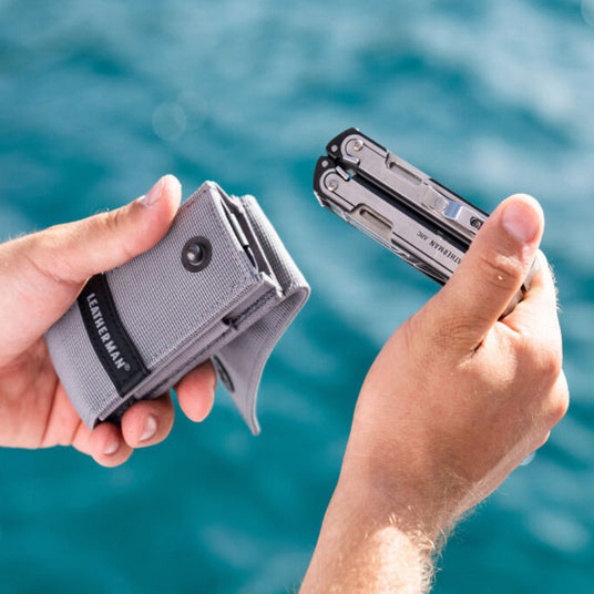 Translation missing: en.Man holding an Arc in one hand and a grey sheath w/pockets in the other hand