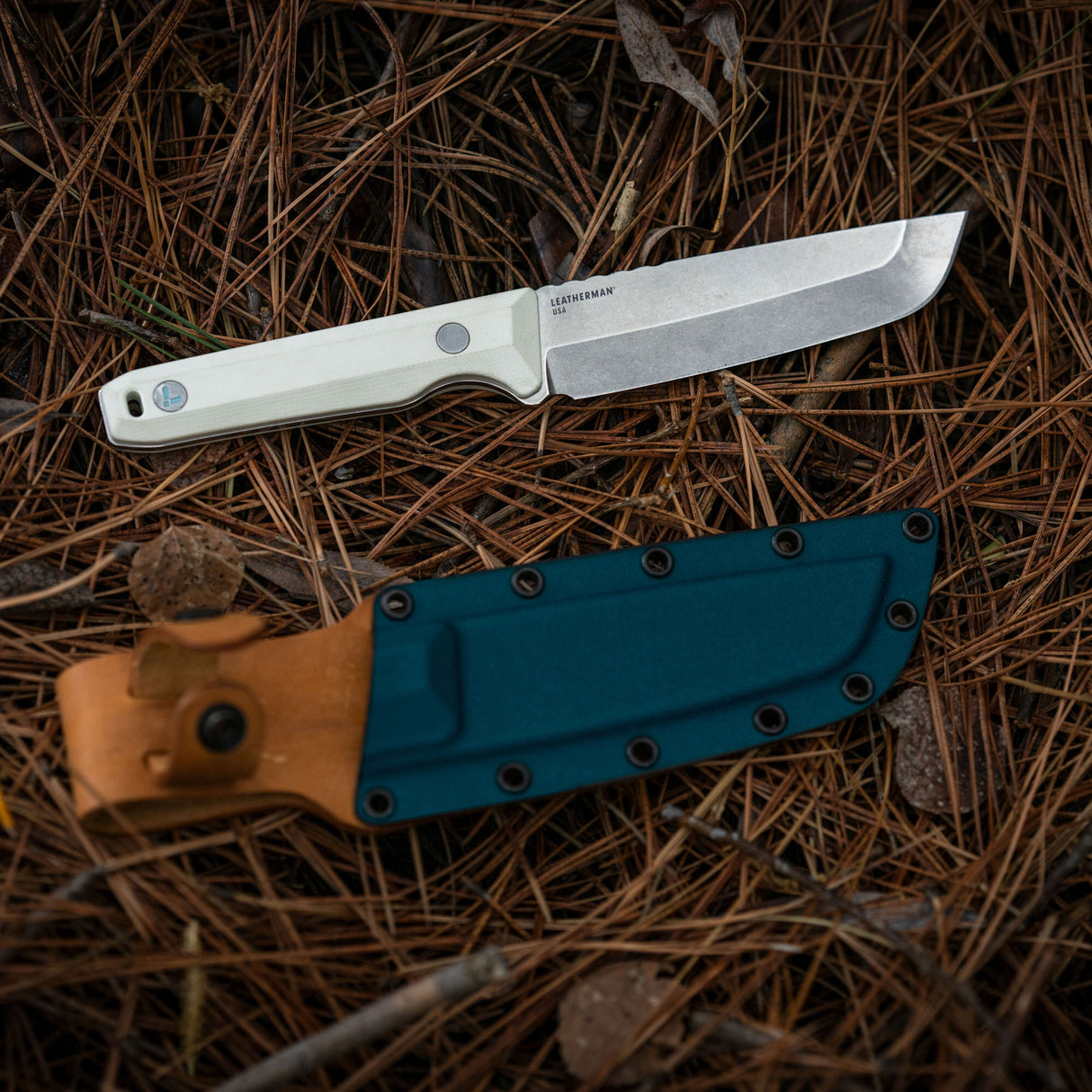 Translation missing: en.Leatherman Alpine Pioneer knife displayed alongside its leather sheath, showcasing the blade and protective cover in a neutral setting