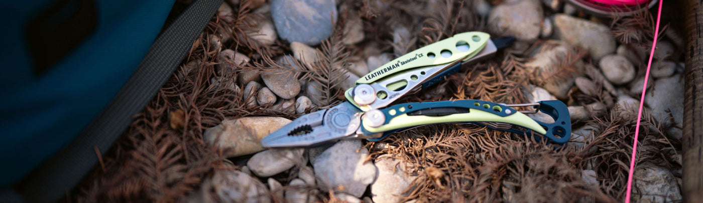 Translation missing: en.Skeletool CX open showing pliers on the ground outside next to a fishing line