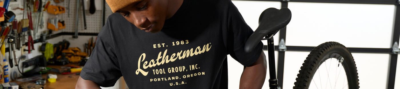 Translation missing: en.Man wearing a black Leatherman Vintage Tee in a workshop setting