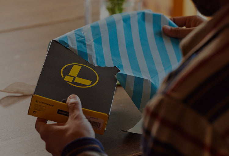 Translation missing: en.A man unwraps a present containing a Leatherman box