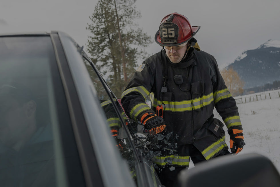 Translation missing: en.A firefighter stands beside a car, wearing protective gear and looking ready for action