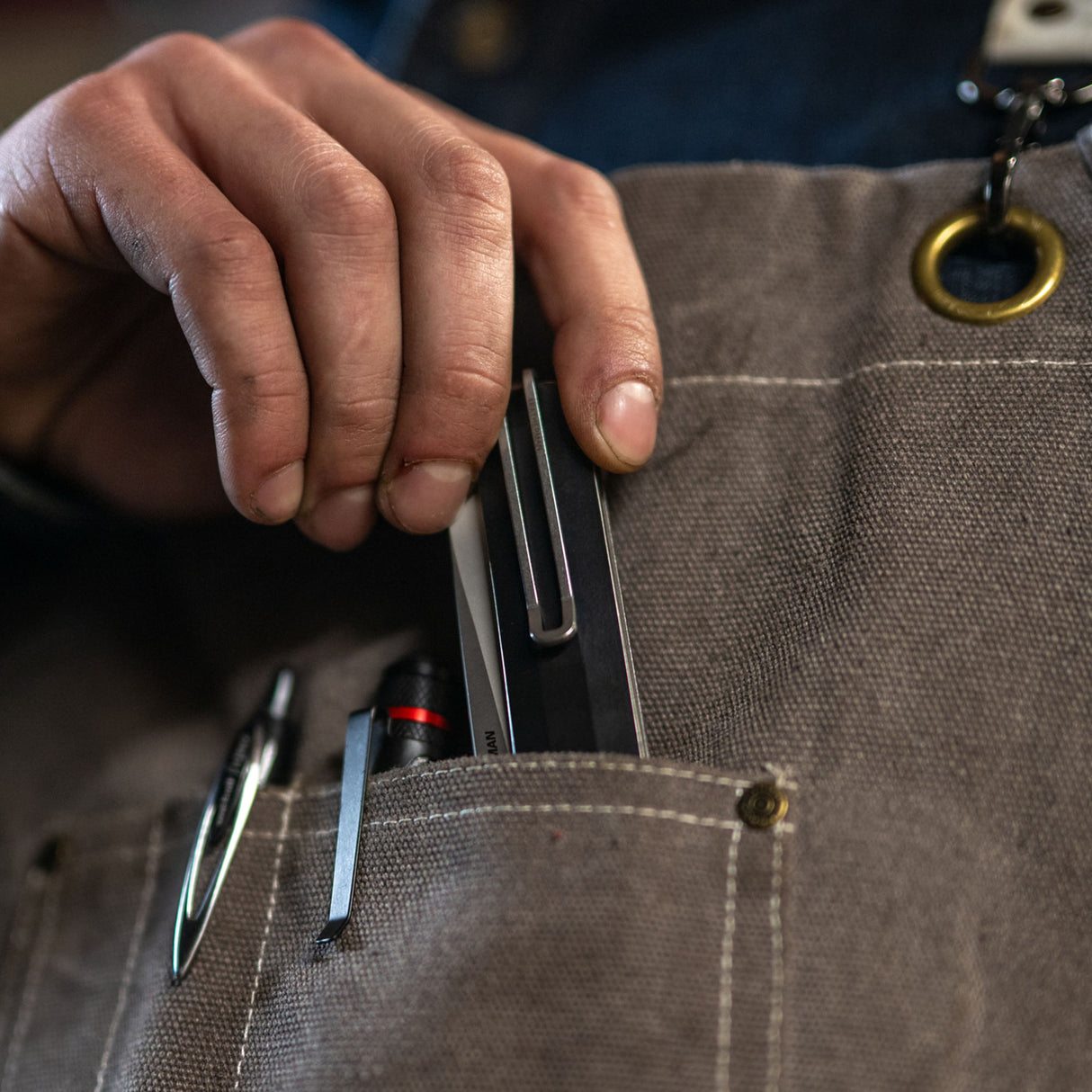 Translation missing: en.A person holds a pen and Leatherman Glider knife in their pocket, suggesting readiness for writing and potential utility tasks