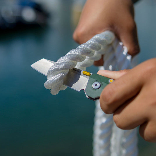 Translation missing: en.Evergreen Leatherman Glider being used on a dock to cut thick, white, mooring rope