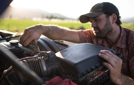 Man using leatherman plier tool to work on truck engine