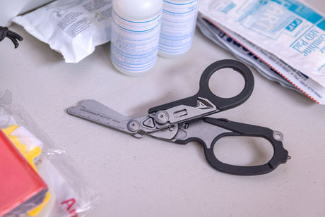 Leatherman Raptor on a table with first aid supplies. 