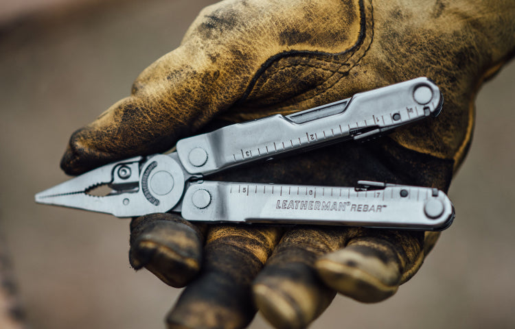 Leatherman Rebar held in dirty work gloved hand