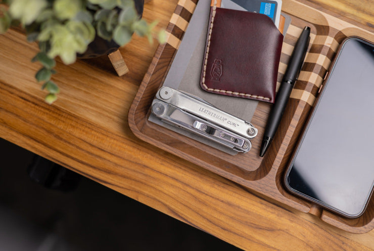 Leatherman Curl on a desk with a wallet, pen and phone.