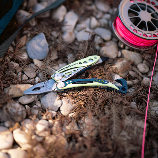 Skeletool CX open on the ground near fishing line