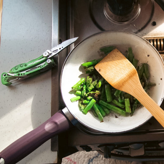 Skeletool with knife open on a counter next to a pot on a stove