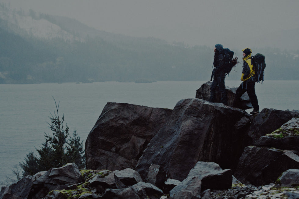 Two mountain hikers looking at lake.