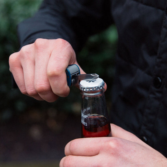 Man opening a glass bottle using FREE T4 bottle opener