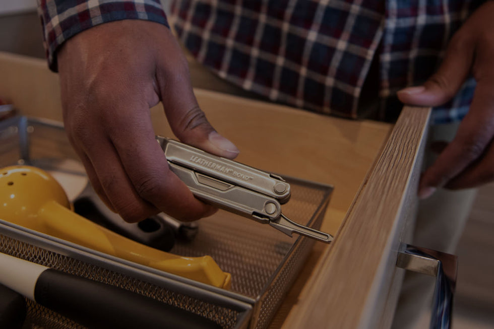 Person using Leatherman bond screwdriver to tighten handle screw on drawer.