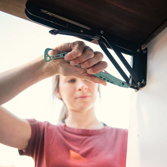 Woman using a Skeletool CX to tighten a screw