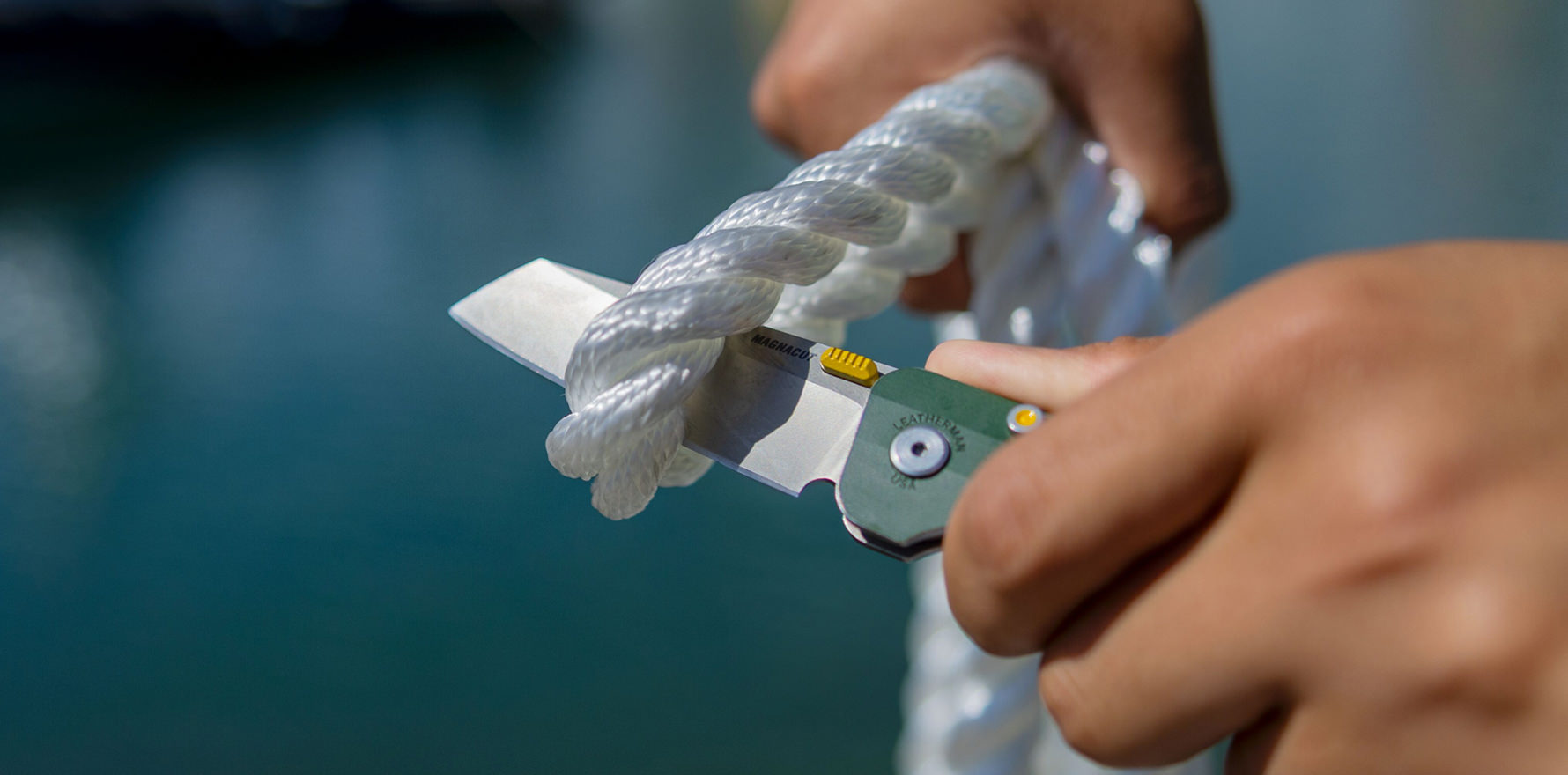 A person skillfully slicing a rope with Leatherman Glider, highlighting the action of severing the material.
