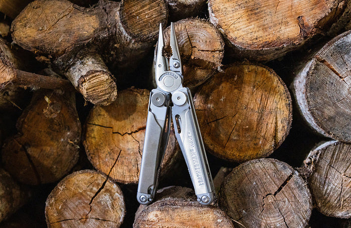 Translation missing: en.Leatherman Wave+ resting on a wooden surface, showcasing their metallic finish against the natural wood grain