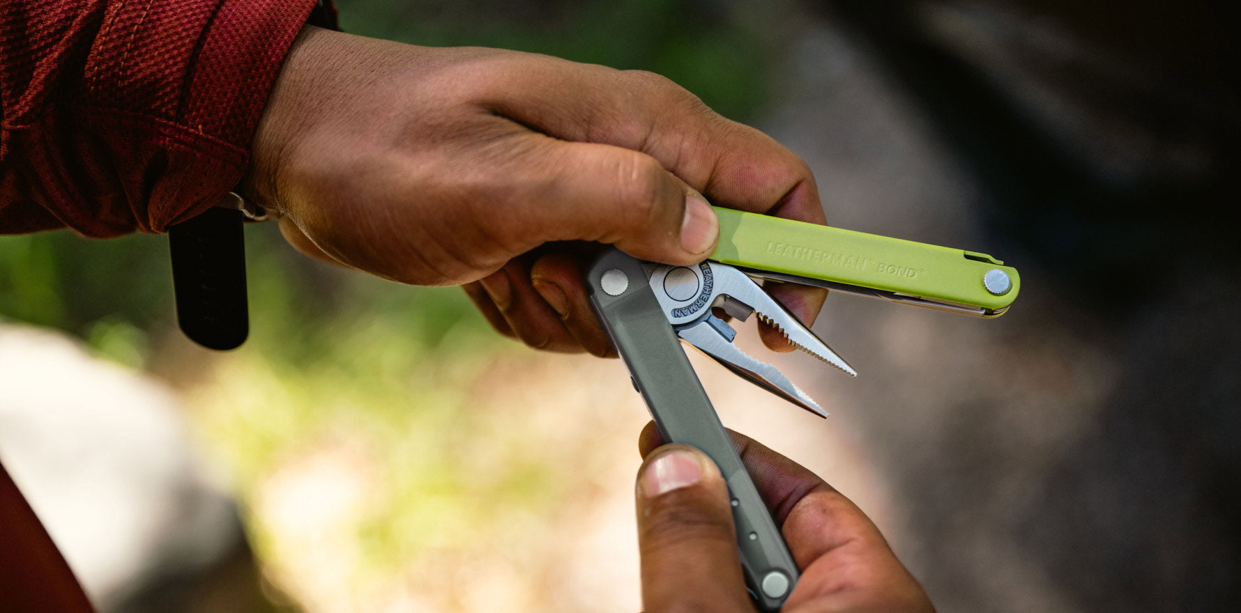 Man holding a Bond partially open showing pliers.